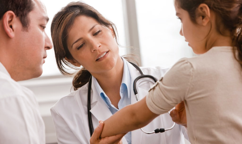 a doctor treats a young patient's broken arm