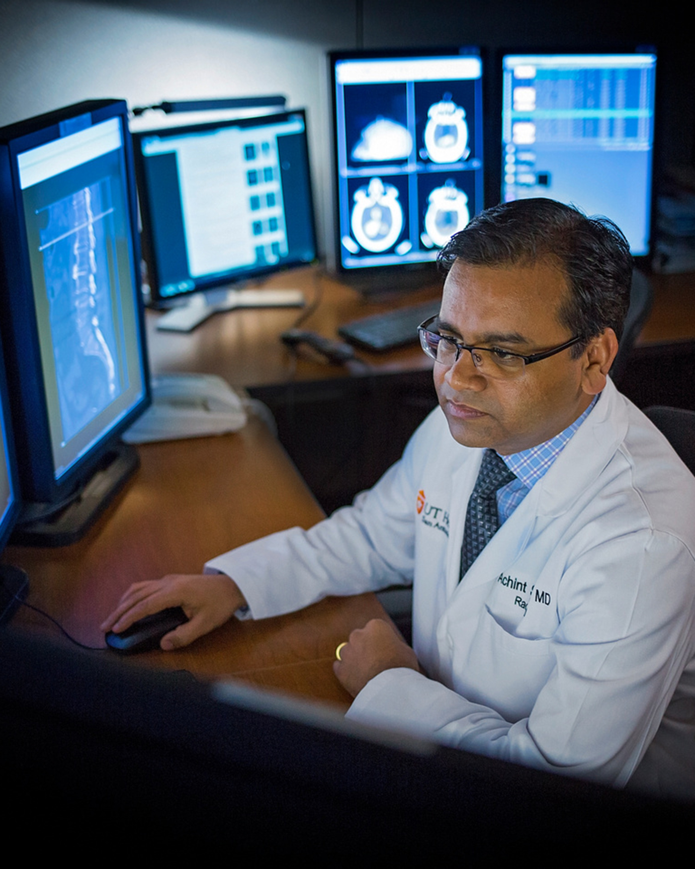 hospital doctor examines x-ray images on computer monitors