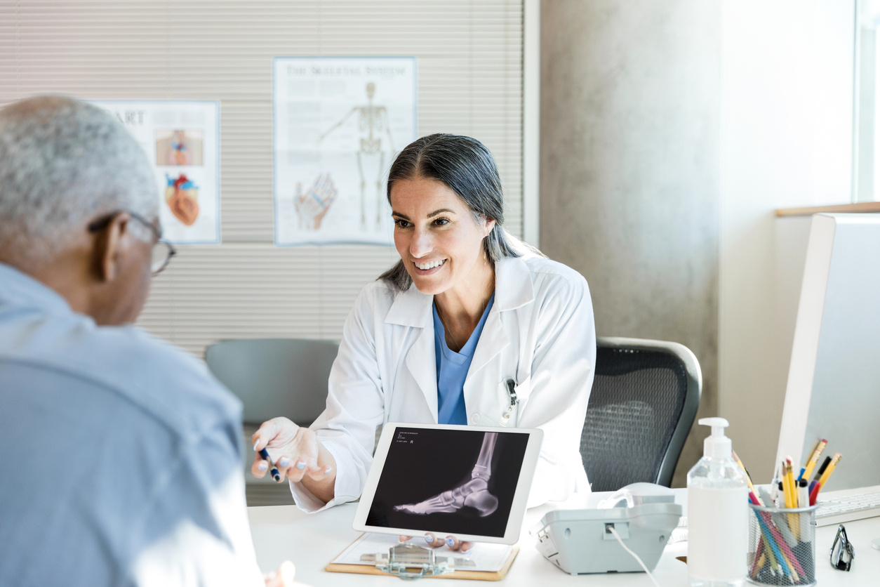 podiatrist and patient examining x-ray of foot