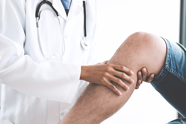 a sports medicine doctor observes the knee and leg of a patient